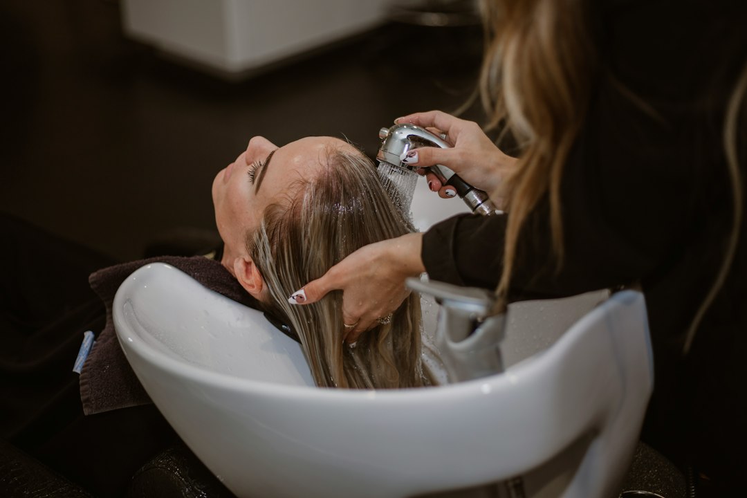 A professional hair stylist giving a haircut to a client